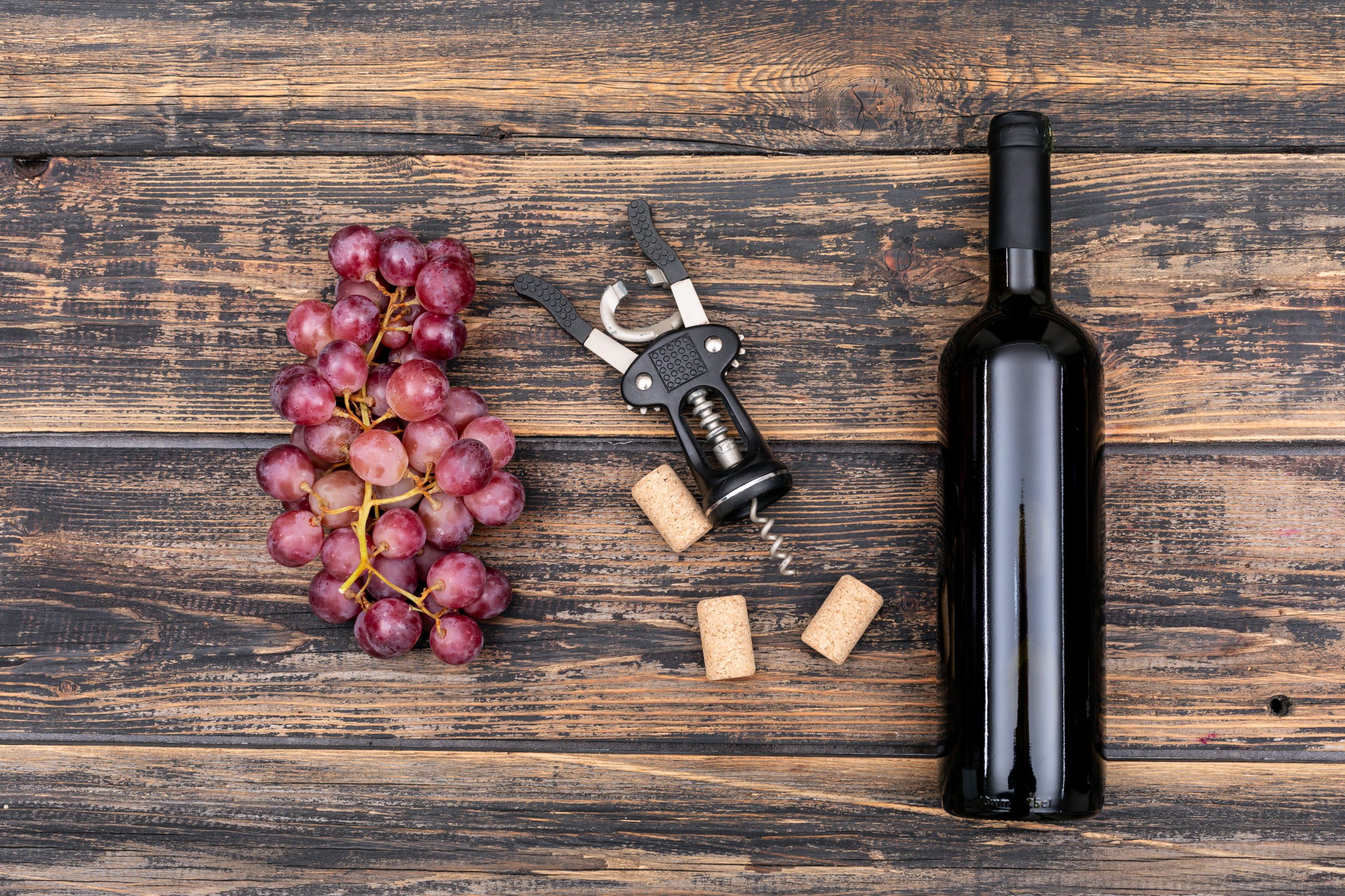 top-view-wine-bottle-with-grape-on-dark-wooden-horizontal